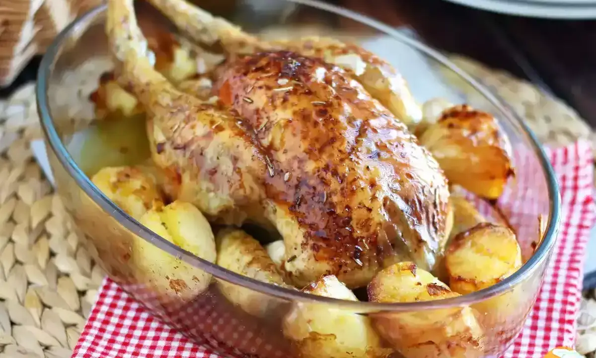 Poulet rôti doré avec pommes de terre dans un plat en verre. Une belle idée pour vos recettes avec poulet.