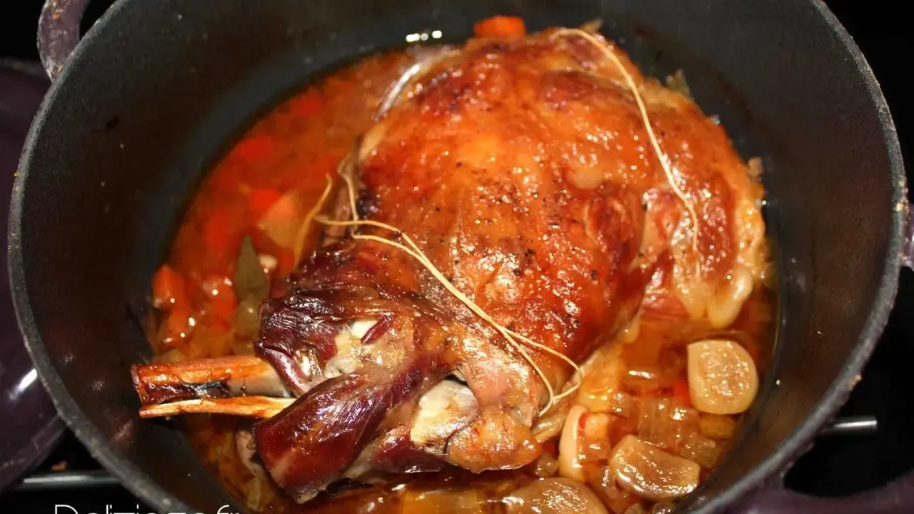 Gigot ou épaule d'agneau de 7 heures, doré et mijotant dans sa sauce avec des oignons et des carottes. Un délice !