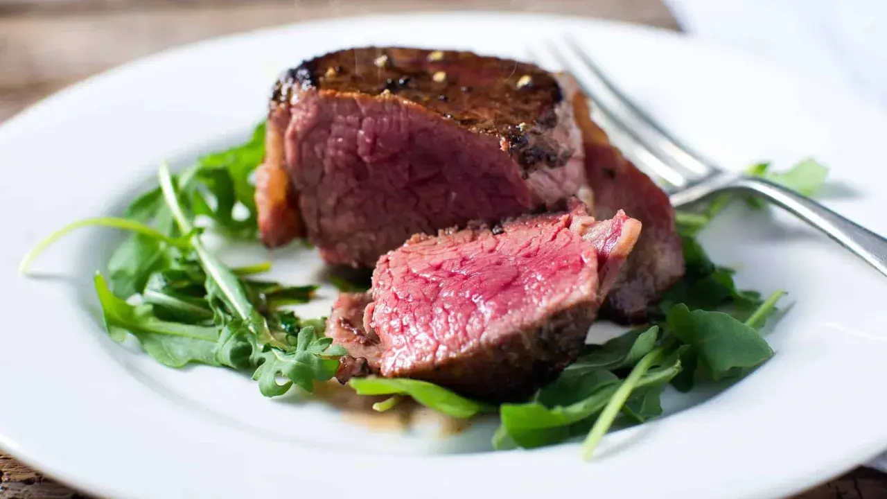 Un délicieux filet mignon, saignant et tendre, servi sur un lit de roquette fraîche.