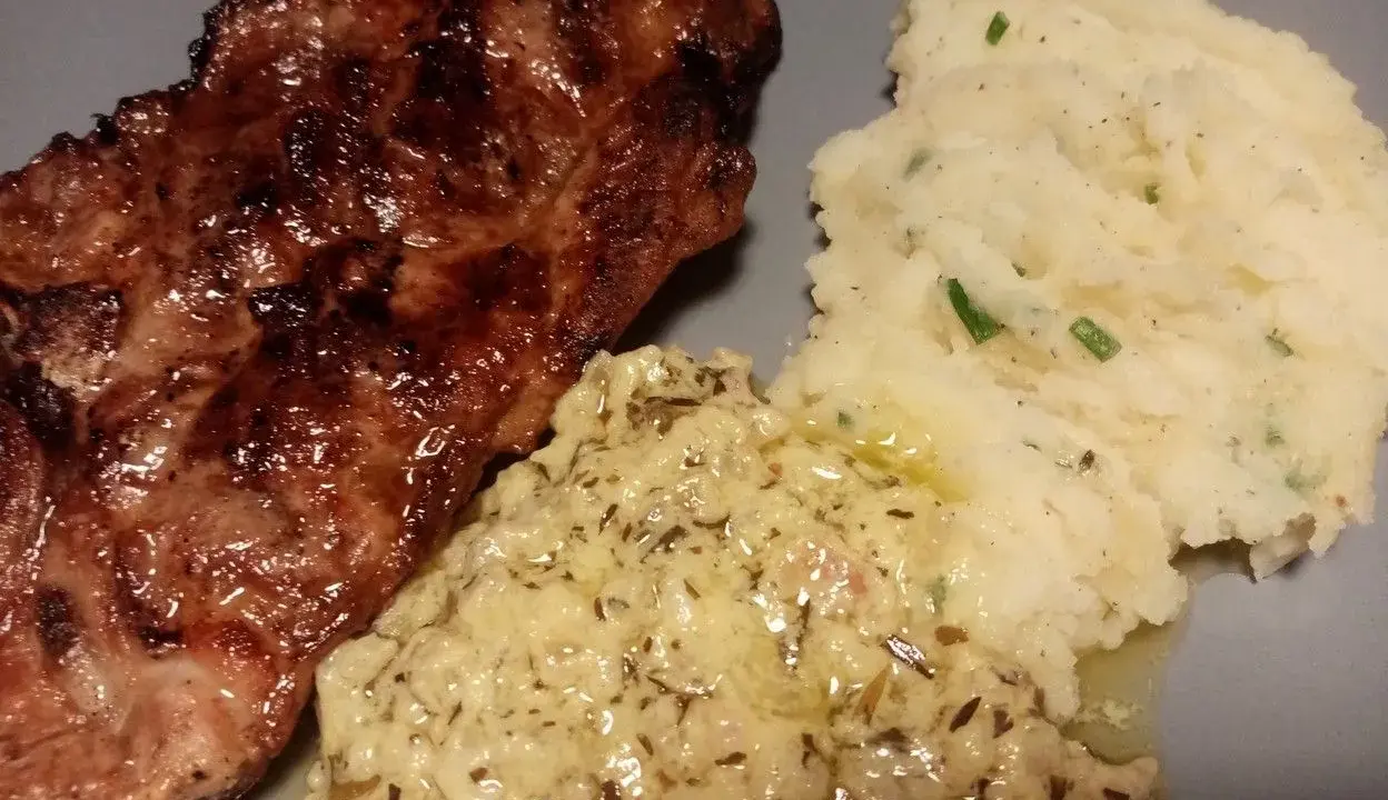 Steak grillé servi avec purée de pommes de terre et une onctueuse sauce à l'estragon pour viande.