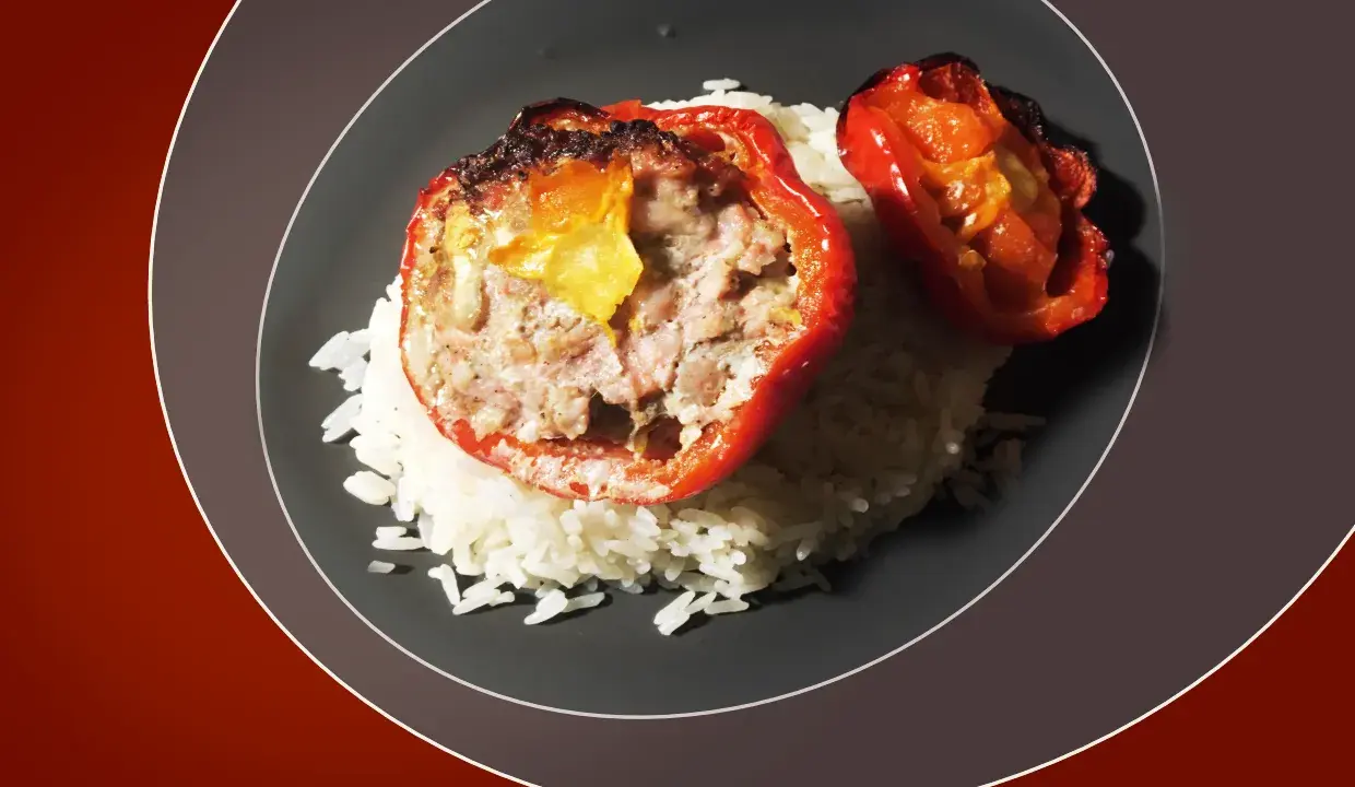 Poivrons rouges farcis à la viande hachée, servis sur un lit de riz blanc. Une recette savoureuse pour savoir quelle viande pour tomates farcies.