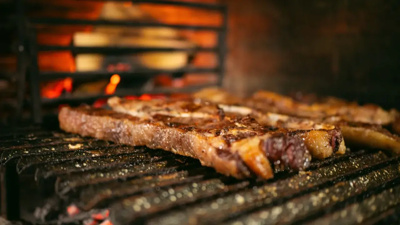 Bifteck grillé sur le feu, prêt à être servi avec une sauce piquante.