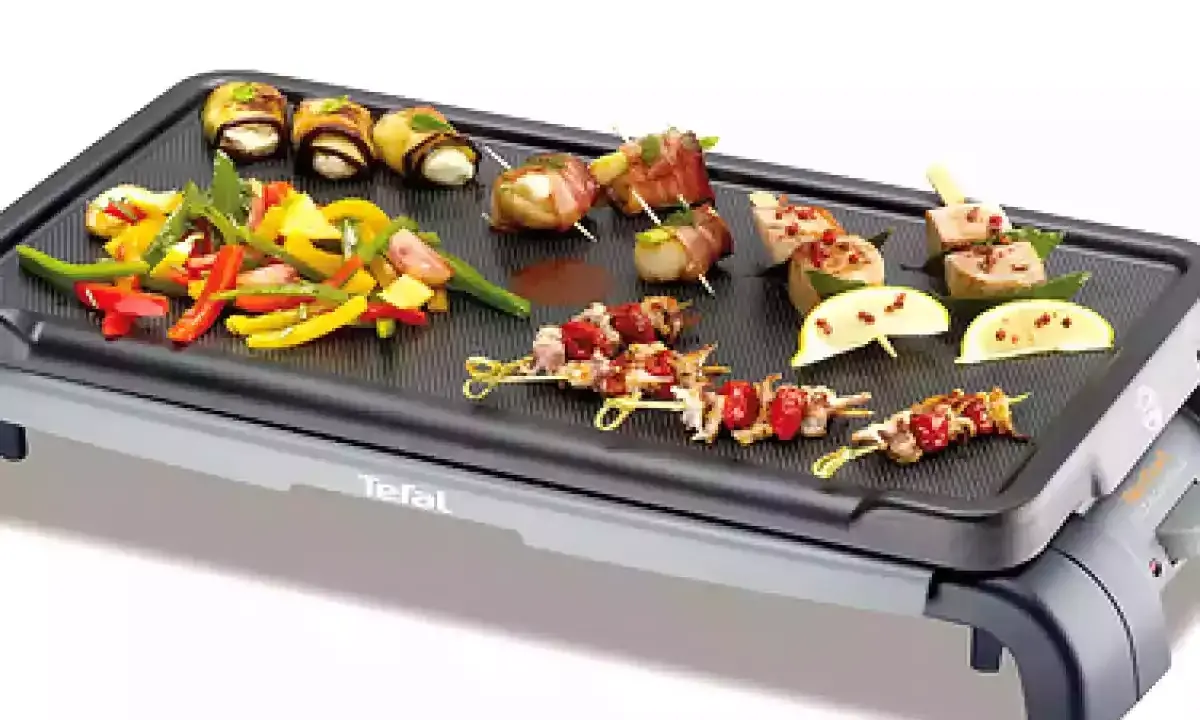 Brochettes de noix de Saint-Jacques et légumes colorés sur une plancha Tefal, prêts à être grillés pour un repas savoureux.