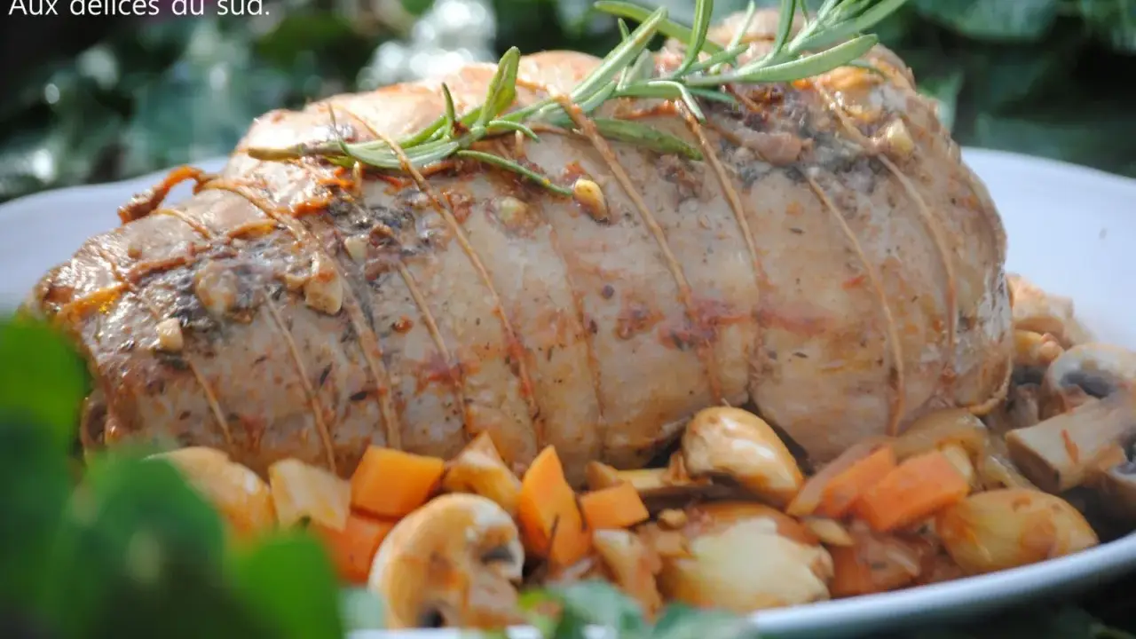 Un rôti d'agneau à la cocotte en fonte, savamment lié et garni de romarin, entouré de légumes rôtis.