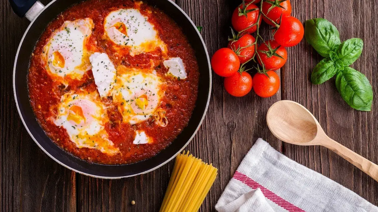 Œufs pochés dans une sauce tomate savoureuse, rappelant la sauce armoricaine, avec des tomates fraîches et du basilic.