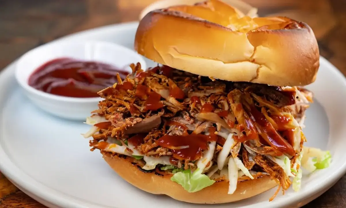 Burger généreux garni d'effiloché de porc savoureux, de salade croquante et nappé de sauce barbecue. Un délice !