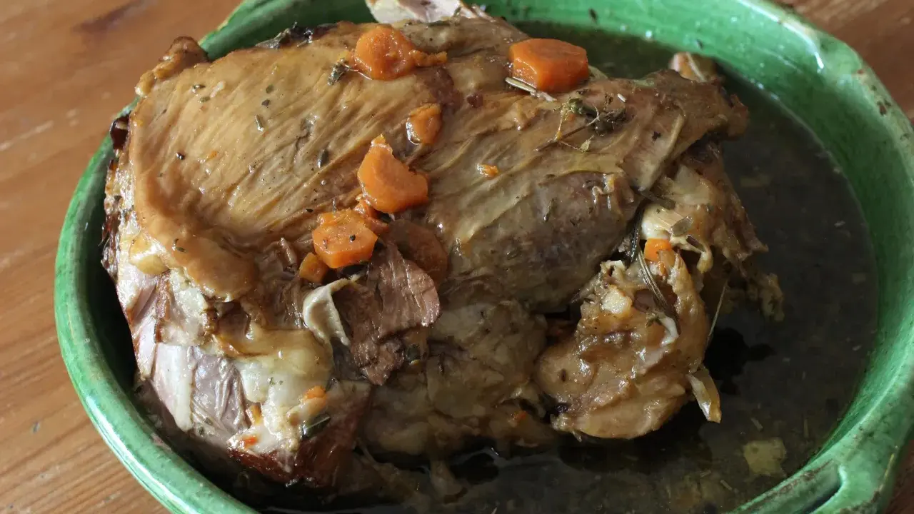 Gigot de 7 heures, un plat mijoté à la perfection, comme dans "Les Carnets de Julie". La viande est tendre et savoureuse, avec des carottes et des herbes.