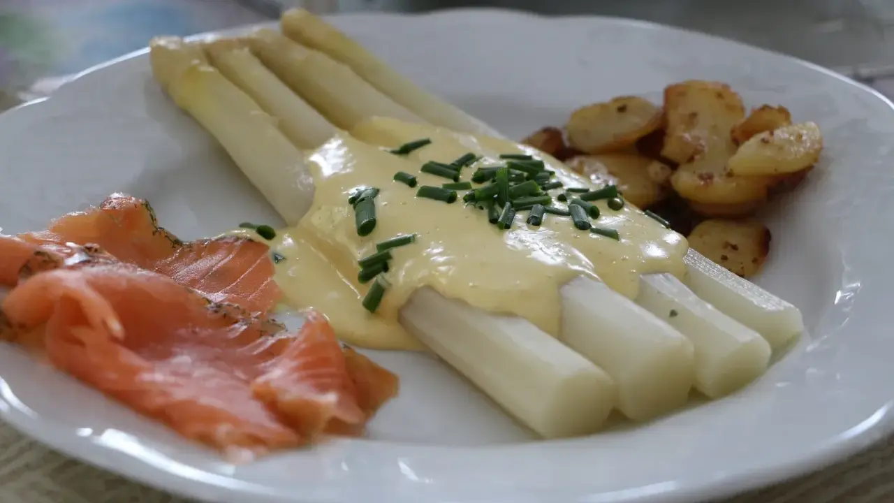 Asperges blanches nappées de sauce hollandaise, accompagnées de saumon fumé et de pommes de terre sautées. Un délice !