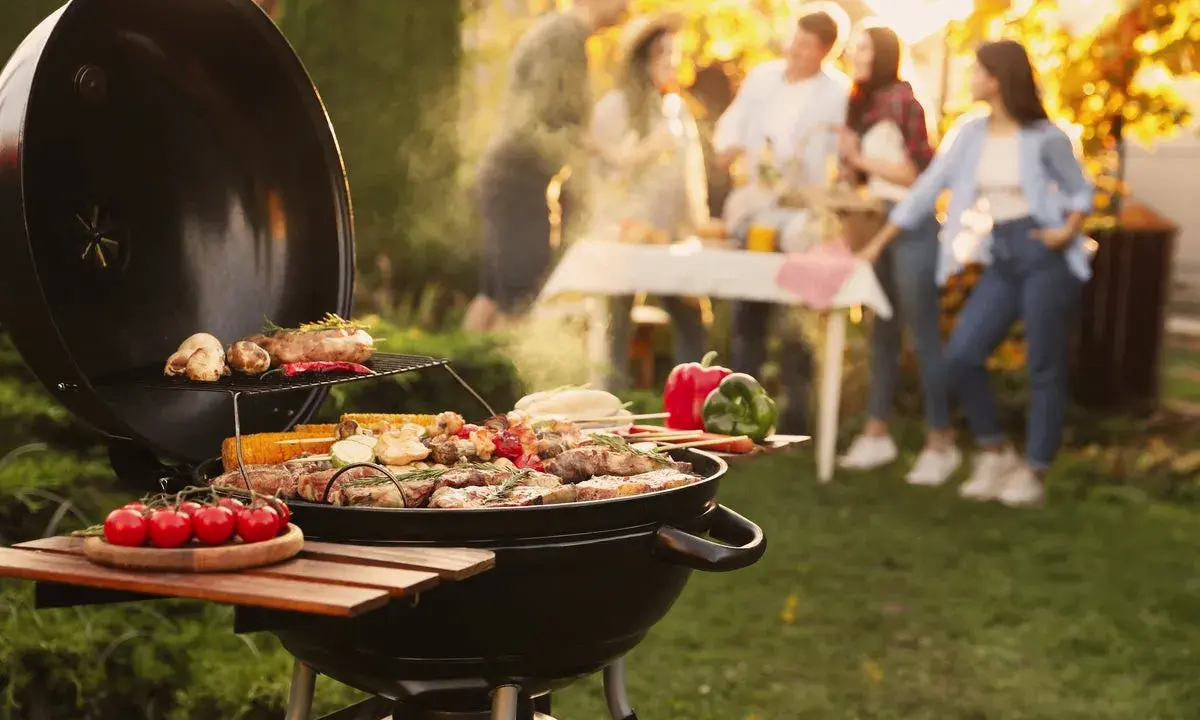 Un barbecue ouvert crépite, cuisant viandes et légumes sous un soleil doré. Des amis discutent joyeusement en arrière-plan, profitant d'un moment convivial.