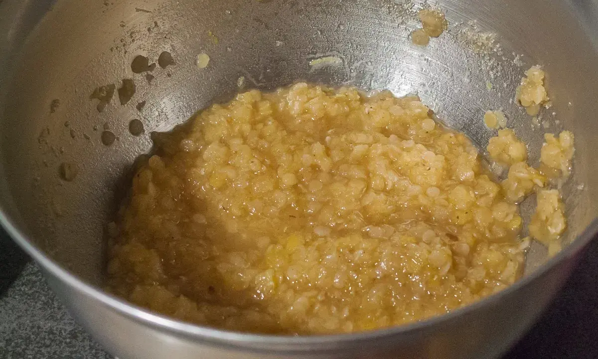 Un bol en métal contient une purée de lentilles corail, prête à être cuisinée.