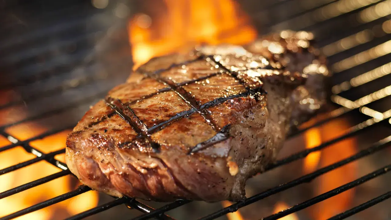 Un délicieux faux filet barbecue, marqué par les flammes, cuit à la perfection sur un grill.