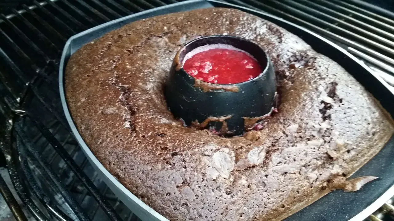 Gâteau au barbecue, un délice chocolaté avec un cœur de coulis de fruits rouges, prêt à être dégusté.