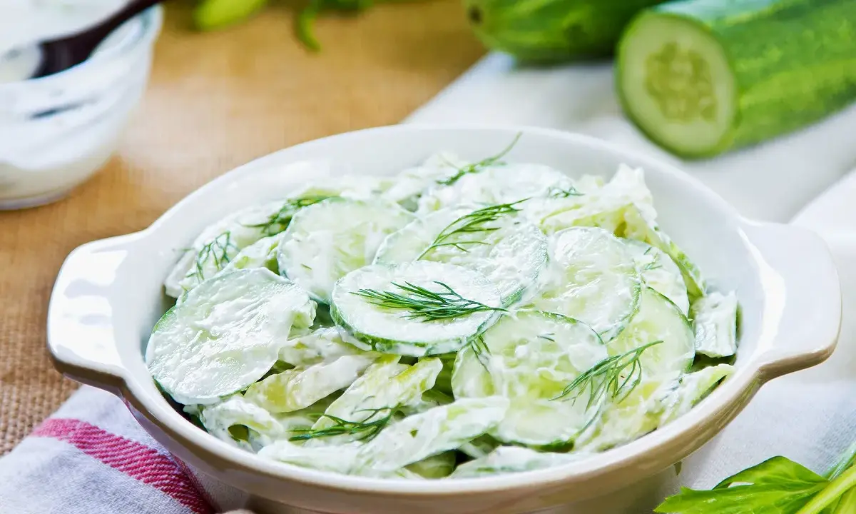 Salade de concombre crémeuse, parfaite pour une recette légère et rafraîchissante. Des rondelles de concombre frais nappées d'une sauce onctueuse et garnies d'aneth.