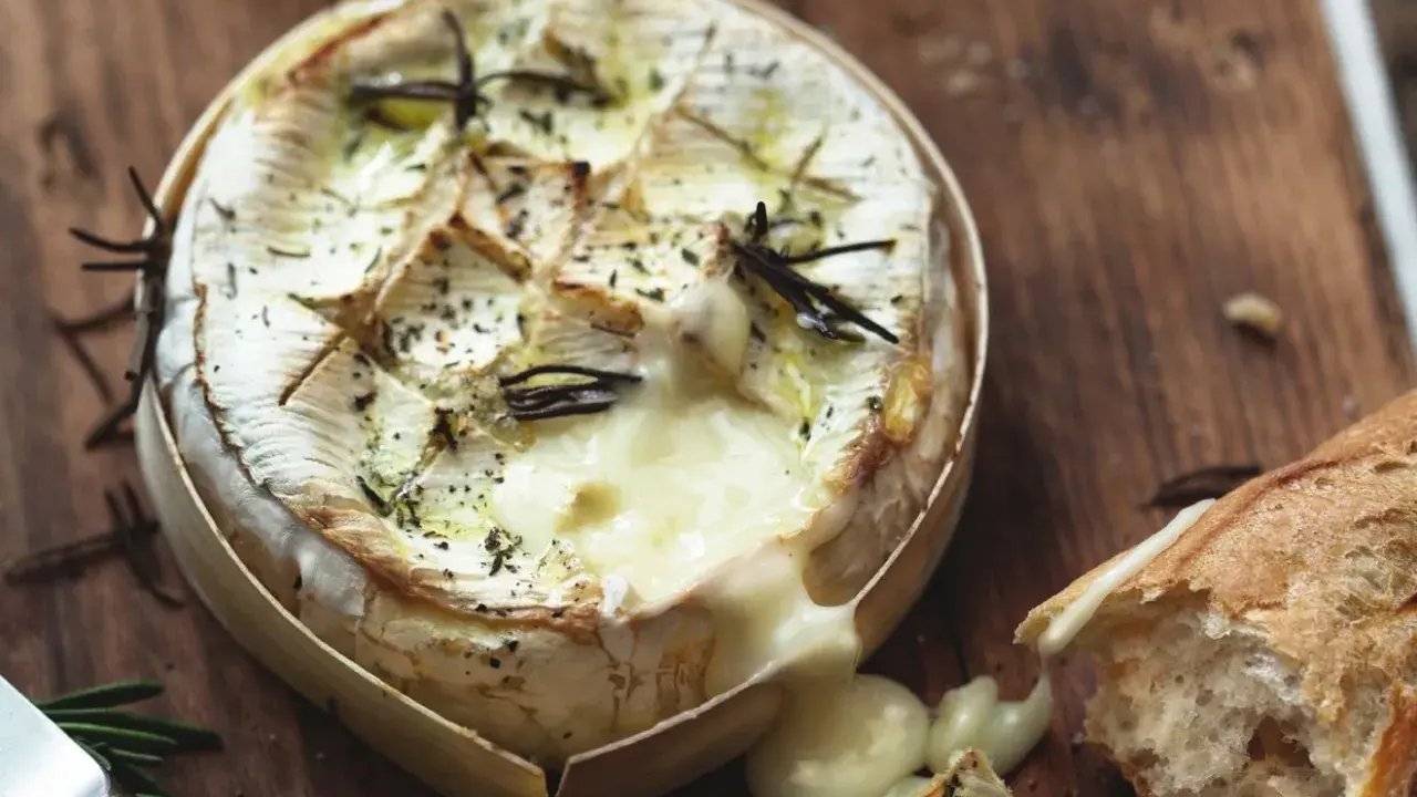 Camembert fondant au barbecue gaz, arrosé d'herbes et servi avec une baguette croustillante. Un délice à partager.