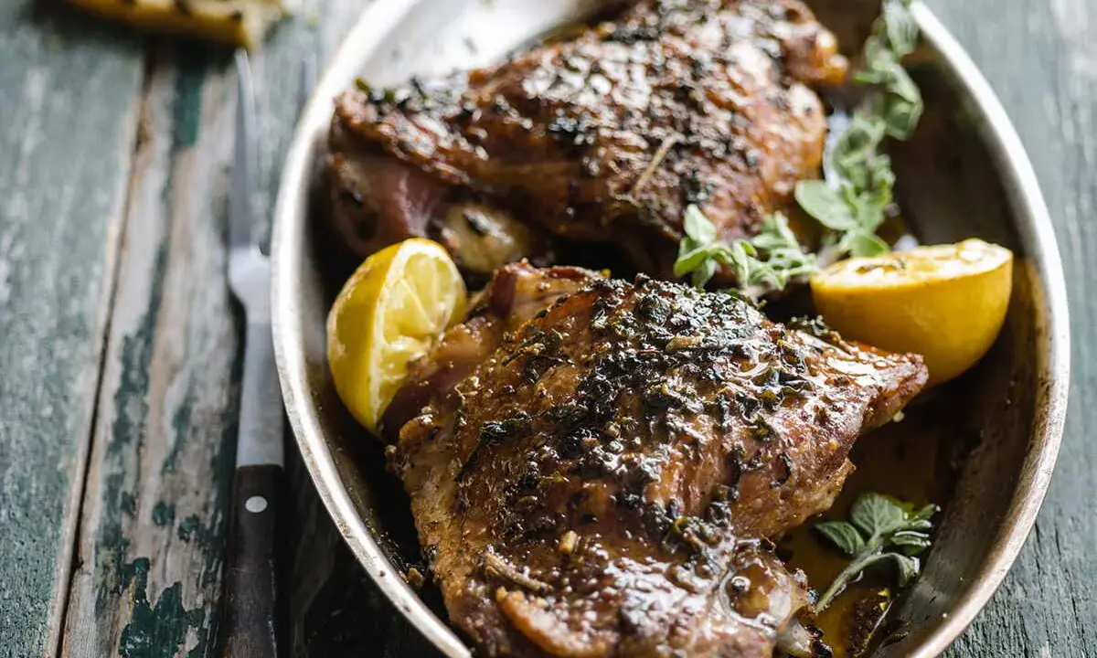Deux belles cuisses de dinde au four, dorées et savoureuses, garnies de citron et d'herbes fraîches. Un délice !