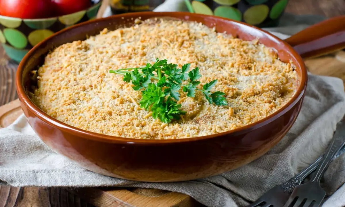 Un délicieux crumble de légumes, doré et croustillant, garni de persil frais. Parfait pour un repas réconfortant.