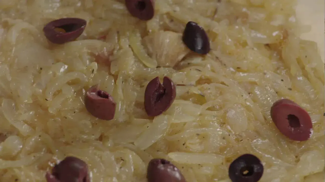 Un délice de confit d'oignon, parsemé d'olives noires, prêt à être dégusté.