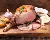 Gigot d'agneau rôti, tendre et juteux, servi avec des pommes de terre nouvelles, de l'ail et une sauce savoureuse. Un accompagnement parfait pour un repas festif.
