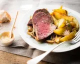 Tranches de roti de boeuf tendre, accompagnées de pommes de terre rôties et d'une sauce moutarde crémeuse.
