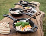 Petits woks de fromage frais, tomates et herbes, servis sur une planche en bois avec du pain grillé. Parfait pour un bbq.