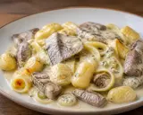 Gnocchis et pâtes fraîches nappés d'une sauce épaisse à la viande et aux herbes. Un plat réconfortant.