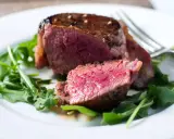 Un délicieux filet mignon, saignant et tendre, servi sur un lit de roquette fraîche.