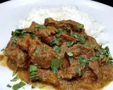Un savoureux curry d'agneau, mijoté et garni de coriandre fraîche, servi avec du riz blanc.