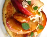 Tranches de fruits grillés sur pain toasté, garnies d'amandes effilées et de menthe.