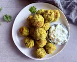 Assiette de falafels dorés, prêts à être dégustés. Une recette facile pour un plaisir garanti. Sauce blanche et coriandre pour accompagner.