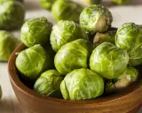 Un bol en bois rempli de choux de Bruxelles frais et verts. Ces petits légumes verts sont prêts à être cuisinés.