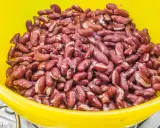 Gros plan sur des haricots rouges dans un bol jaune, prêts pour une délicieuse recette haricot rouge.