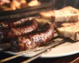 Figatelli grillés au four, accompagnés de pain grillé. Un délice simple et savoureux.