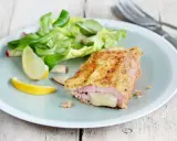 Un délicieux cordon bleu croustillant, garni de fromage fondant, servi avec une salade fraîche et des quartiers de citron.