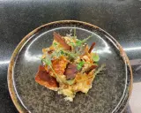 Une assiette de truffade recette, garnie de fines herbes et de lardons croustillants. Un plat réconfortant et savoureux.