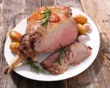 Gigot d'agneau rôti, tendre et juteux, accompagné de pommes de terre et d'ail. Un plat parfait pour un gigot pour 10 personnes.
