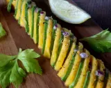 Une belle recette avocat et mangue, assaisonnée d'oignon rouge et de poivre, sur une planche en bois.