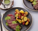 Tranches de bœuf juteux nappées de pesto, accompagnées de pommes de terre rôties et de tomates séchées. Quelle viande avec du pesto, un délice !