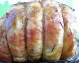Un rôti de veau savoureux, enveloppé de lard et parsemé de romarin, prêt à être dégusté.