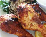 Trois pilons de poulet grillés et dorés, servis avec du riz et une tranche de citron.