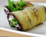 Rouleaux d'aubergine farcie au fromage et aux herbes, garniture appétissante.