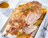Gigot d'agneau pour 6 personnes, rôti à la perfection, servi avec sa sauce et garni de romarin.