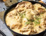 Poulet de Bresse à la crème, servi dans une poêle, garni d'aneth.