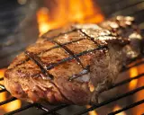 Un délicieux faux filet barbecue, marqué par les flammes, cuit à la perfection sur un grill.