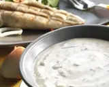 Sauce blanche crémeuse avec herbes, peut-être une différence sauce tartare et béarnaise. Poisson grillé en arrière-plan.
