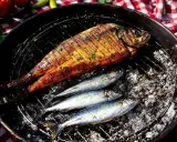 Poisson grillé sur barbecue à gaz. Le temps de cuisson des sardines est court, parfait pour un repas d'été.