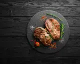 Deux belles tranches de gigot d'agneau au barbecue, parfaites pour un repas savoureux. Le temps de cuisson idéal pour cette viande tendre.