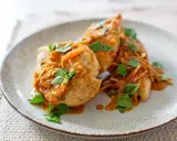 Trois escalopes de poulet nappées d'une sauce onctueuse aux oignons caramélisés et garnies de persil frais. Un plat savoureux et réconfortant.