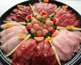 Plateau de viandes variées pour fondue, évoquant la fondue bourguignonne et son origine. On y trouve bœuf, poulet, agneau, porc, veau et gibier.