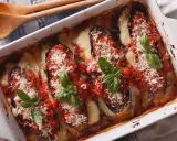 Aubergine parmigiana gratinée, garnie de sauce tomate, fromage fondant et basilic frais. Un délice italien prêt à être dégusté.