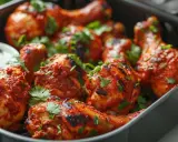 Un plat de poulet tandoori, bien épicé et garni de coriandre fraîche, prêt à être dégusté.